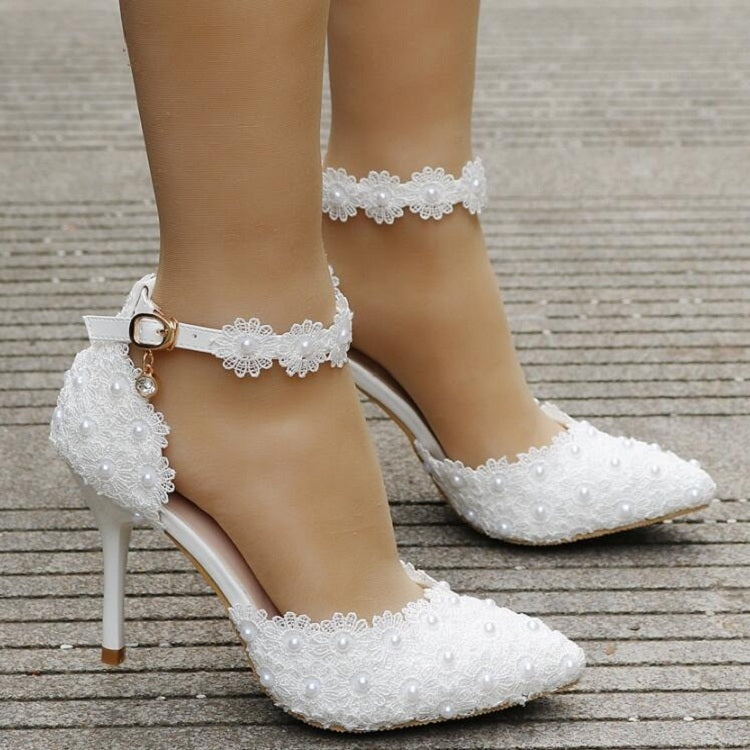 White lace high heels with ankle strap and dangling charm, pointed toe and stiletto heel