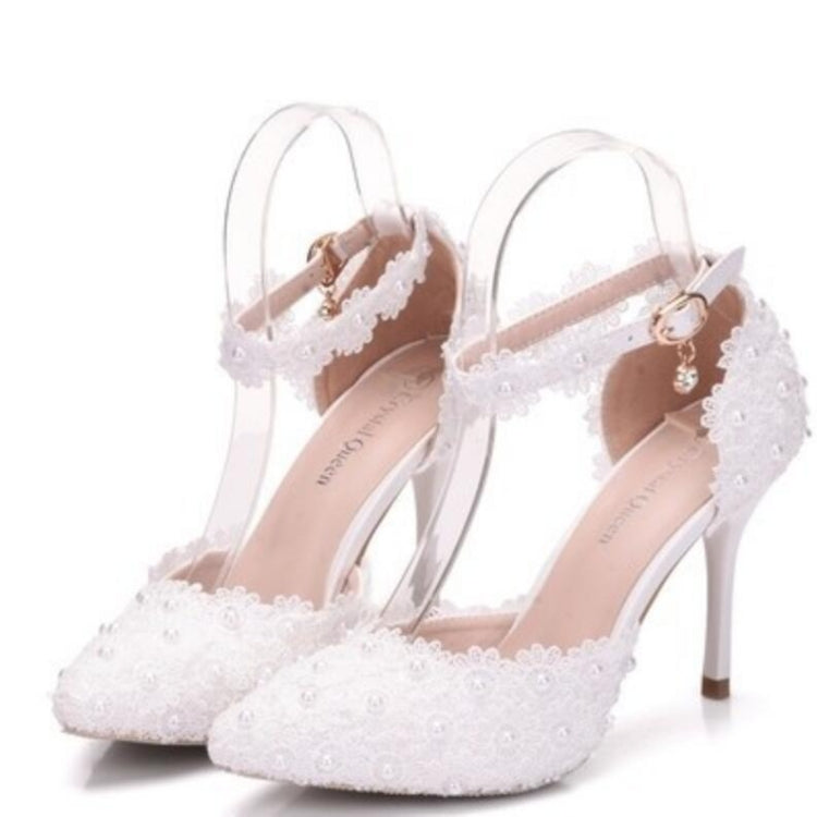 Pair of women's lace pointed heels with pearl embellishment and ankle strap, white