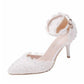 Angle shot of women's white lace pointed heels with pearl ankle strap and slim heel