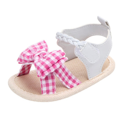 Baby sandal with pink gingham bow, white T-strap, and soft woven anti-slip sole