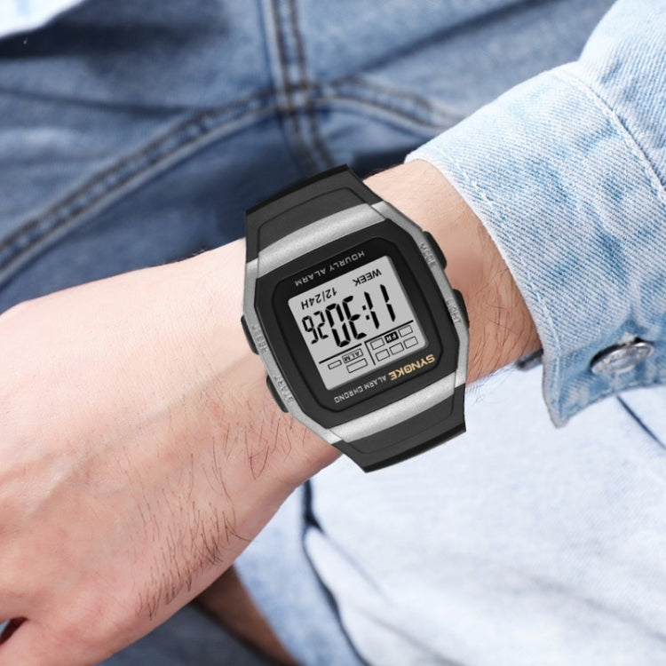 Digital sports watch on wrist with black strap and LCD showing 12/24-hour time