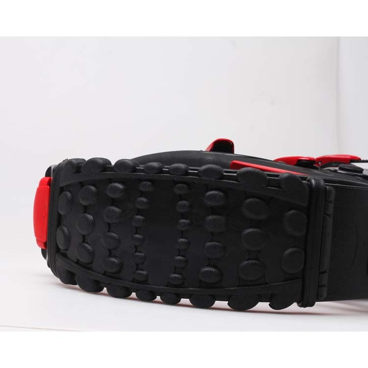 Black textured outsole with red side edges and adjustable safety strap