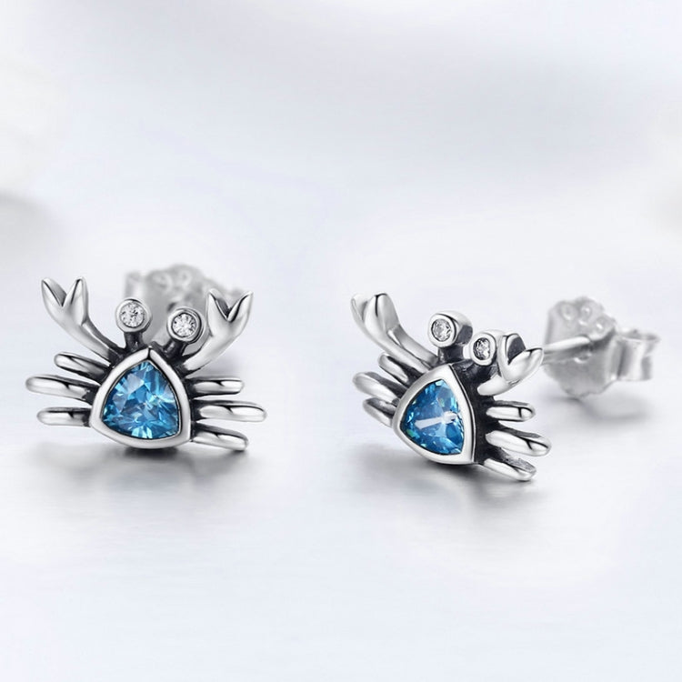 Oxidized silver crab stud earrings with blue heart-shaped gemstone and round clear stones