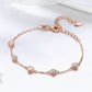 Rose gold plated zircon bracelet close-up with oval crystal stations on slim chain