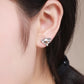 Koala stud earrings worn on an ear, polished silver with brown enamel koala face