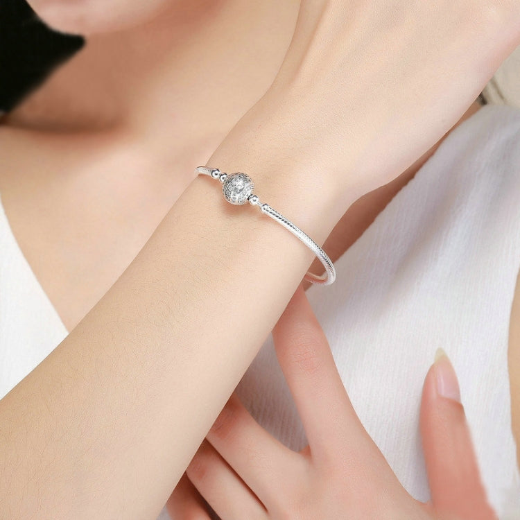 Sterling silver bangle bracelet with round paved bead worn on wrist