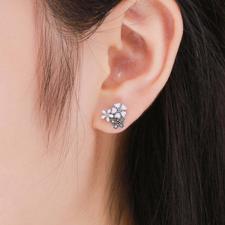 Small sterling silver pink enamel flower stud earrings with cubic zirconia on ear