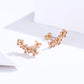 Rose gold flower CZ stud earrings with butterfly backs, side view