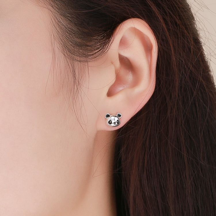 Panda face sterling silver stud earrings worn on ear, black enamel details