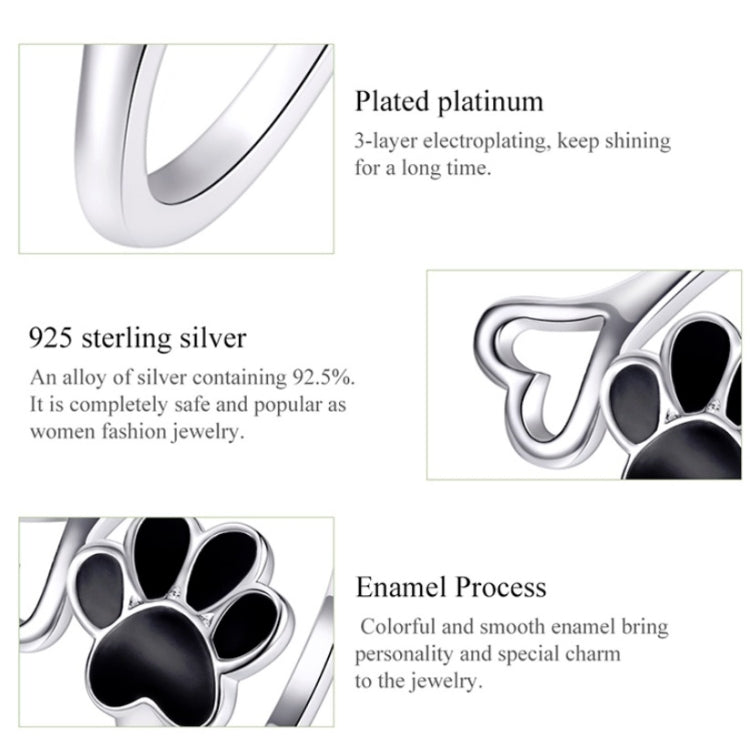 Close-up of open paw print ring with black enamel center on silver band