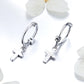 Silver hoop earrings with cross dangle charm and small textured details