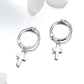 Silver cross hoop earrings with dangling cross charms, side view