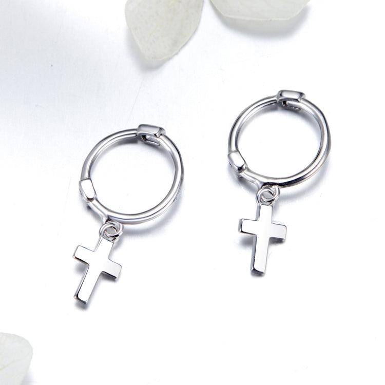 Silver cross hoop earrings with dangling cross charms, side view