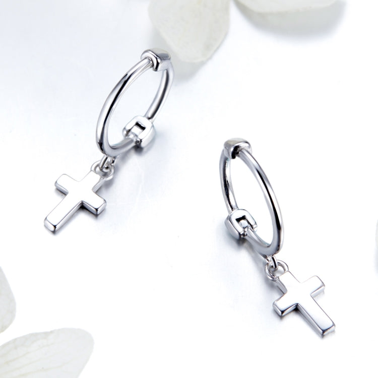 Sterling silver cross hoop earrings with dangling cross charm, angled view