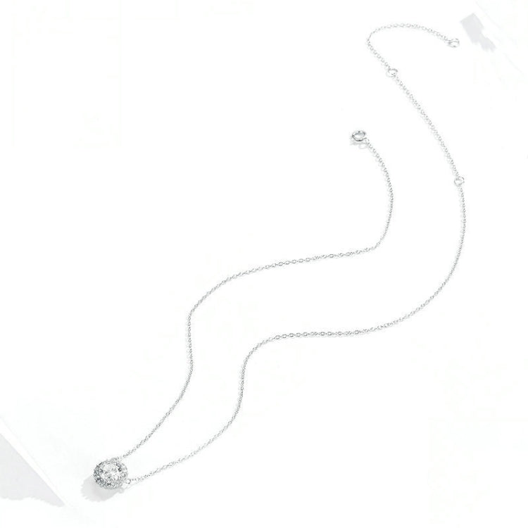 Silver zircon pendant necklace with round halo setting and chain links, angled view