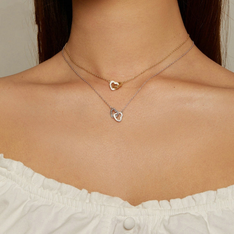 Layered heart pendant necklaces in gold and silver with CZ stone details