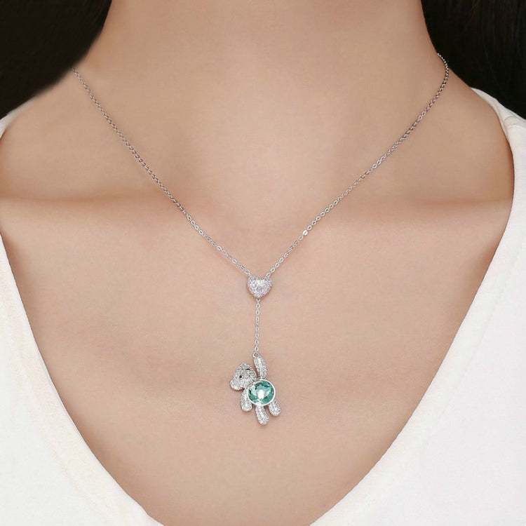 Wearing sterling silver bear necklace with pink heart CZ and teal crystal pendant