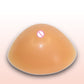 Triangular concave silicone breast prosthesis, smooth tan, front-facing view
