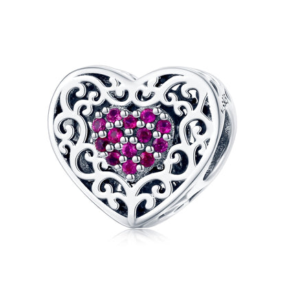 Sterling silver heart-shaped bead with filigree and pink stone center