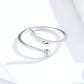Silver open ring with angel wings detail and small lower charm, side view