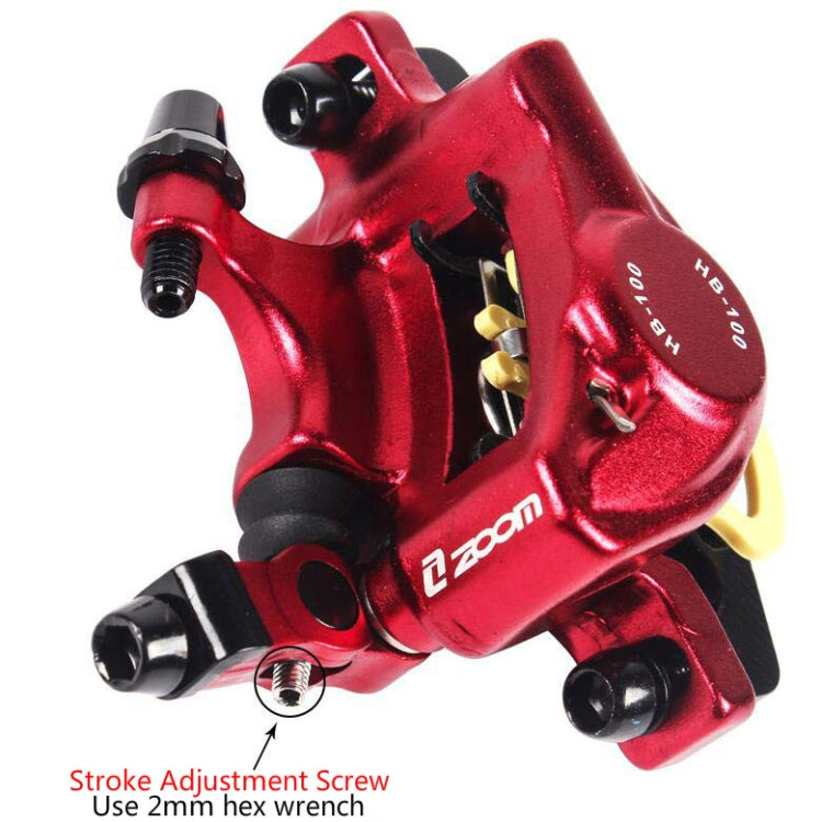 Red hydraulic disc brake caliper close-up with adjustment screw area and mounting points