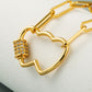 Close-up of gold-tone heart pendant necklace with round multicolor zircon at the side