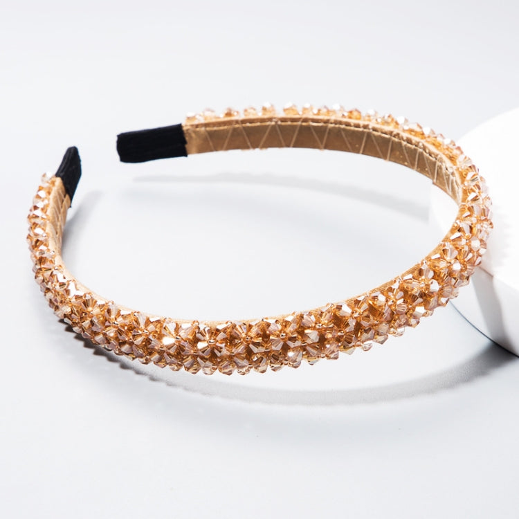 Warm tan/copper crystal beaded headband with black fabric tips and a curved shape
