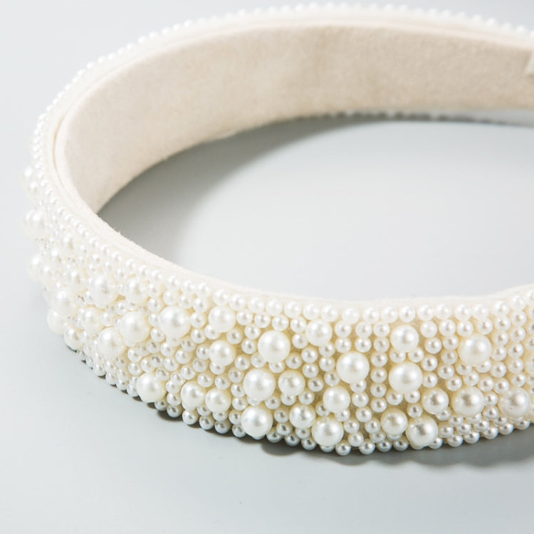 Wide white faux pearl headband with beige lining and dense beadwork across the front.