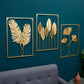Gold metal leaf wall hanging set of three framed botanical designs on teal wall