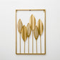 Gold metal leaf wall hanging in rectangular frame with five slender stems and leaves