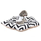Pet sleeping mat bed with black-and-white zigzag cover, with small dog resting