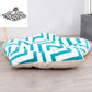 Dog sleeping mat bed with bold turquoise geometric shapes on white top and cream base