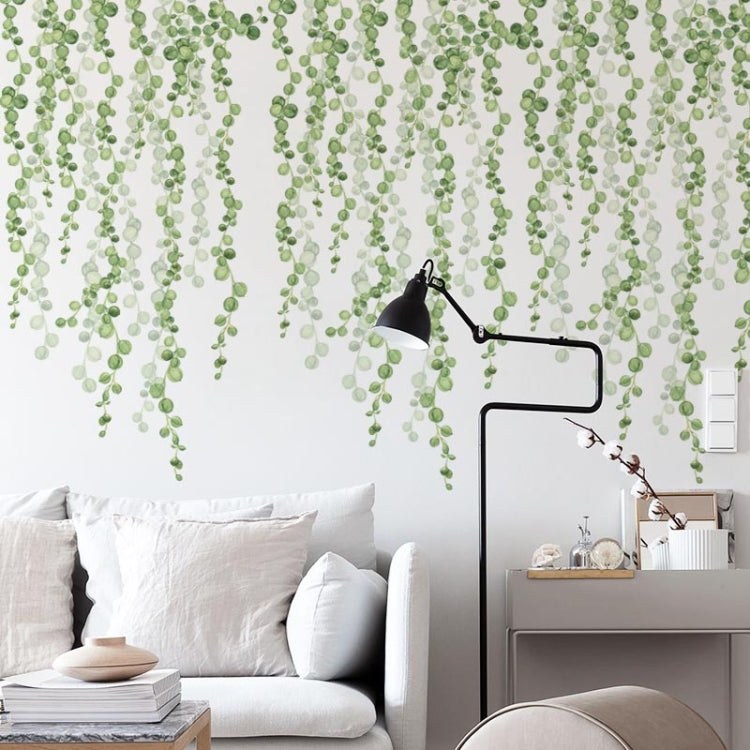 Green leaf dangling wall stickers with multiple vine clusters over a living room wall