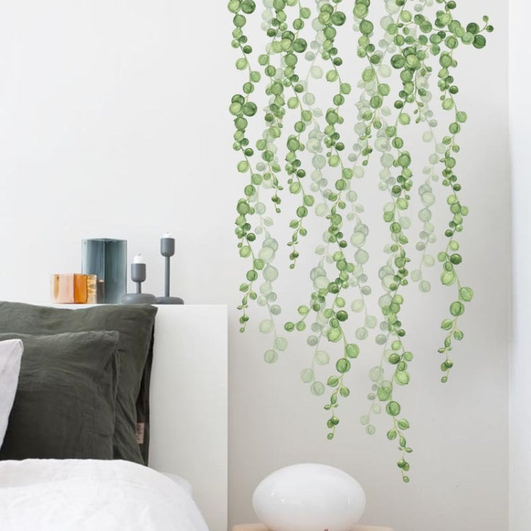 Green leaf dangling wall stickers arranged in layered draping vines on a white wall