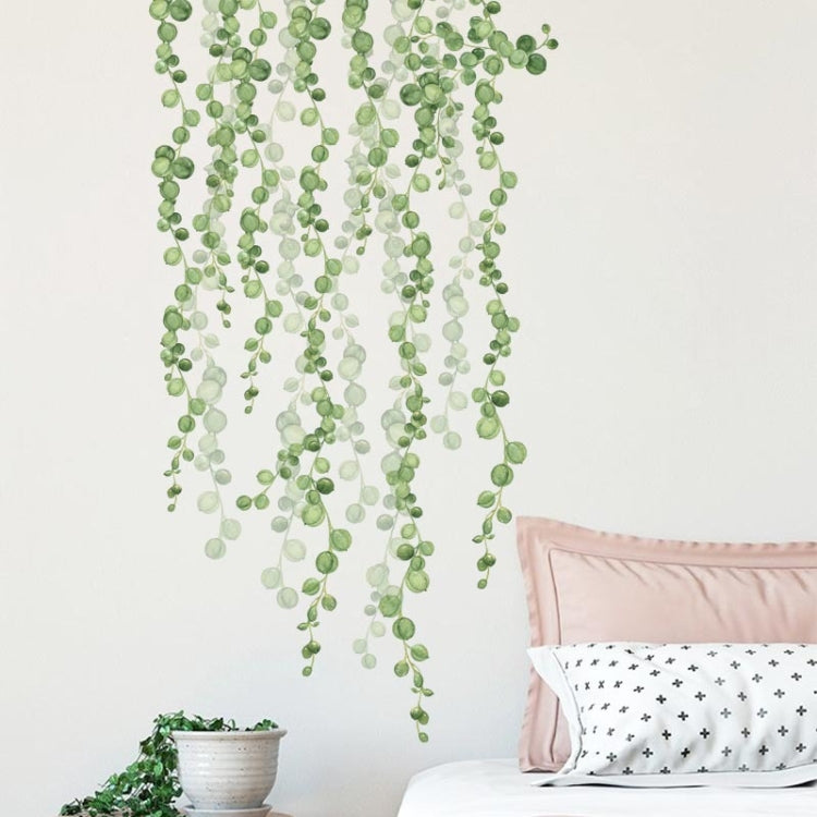 Green leaf dangling wall stickers with dense hanging vine strands above a bed