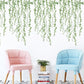 Green leaf dangling wall stickers covering the upper wall above two armchairs
