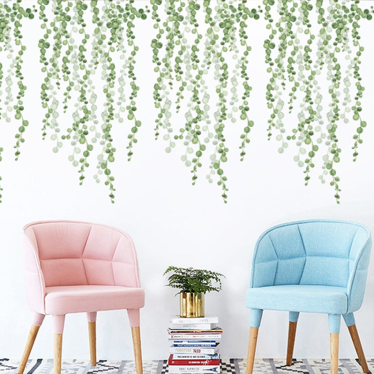 Green leaf dangling wall stickers covering the upper wall above two armchairs