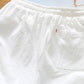 White cotton-linen five-point shorts with elastic waistband and stitched panel detail