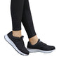 Women's black mesh lace-up sneakers worn with black pants and white midsole