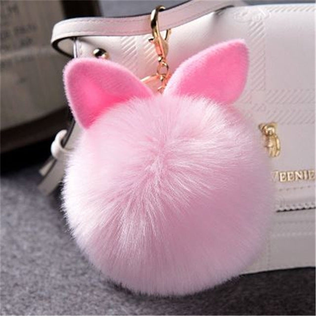 Pink faux-fur ball keychain with bunny ears and gold-tone clasp