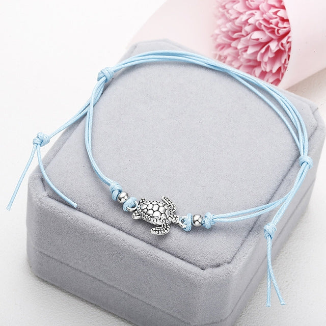 Light blue wax string anklet with sea turtle charm and knot tie tassels