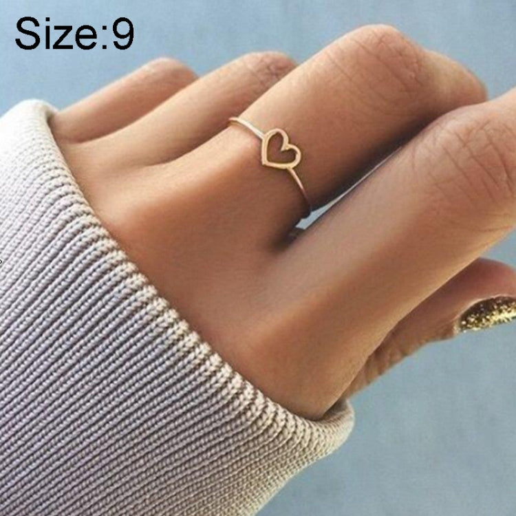 Rose gold-tone heart wedding ring on finger, Size 9