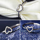 Silver-tone heart ring on white ribbon and blue glitter backgrounds