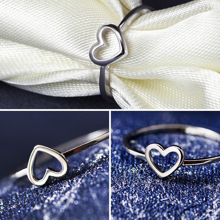 Silver-tone heart ring on white ribbon and blue glitter backgrounds