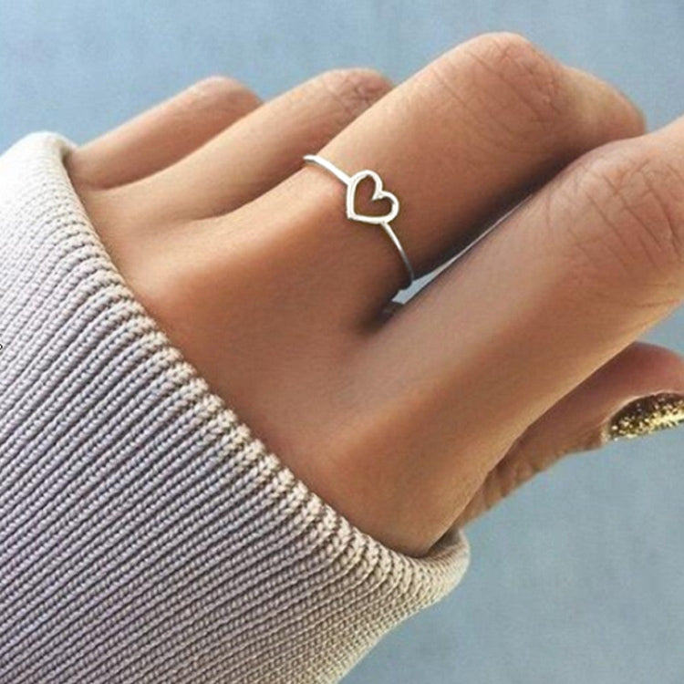 Rose gold-tone heart wedding ring on finger