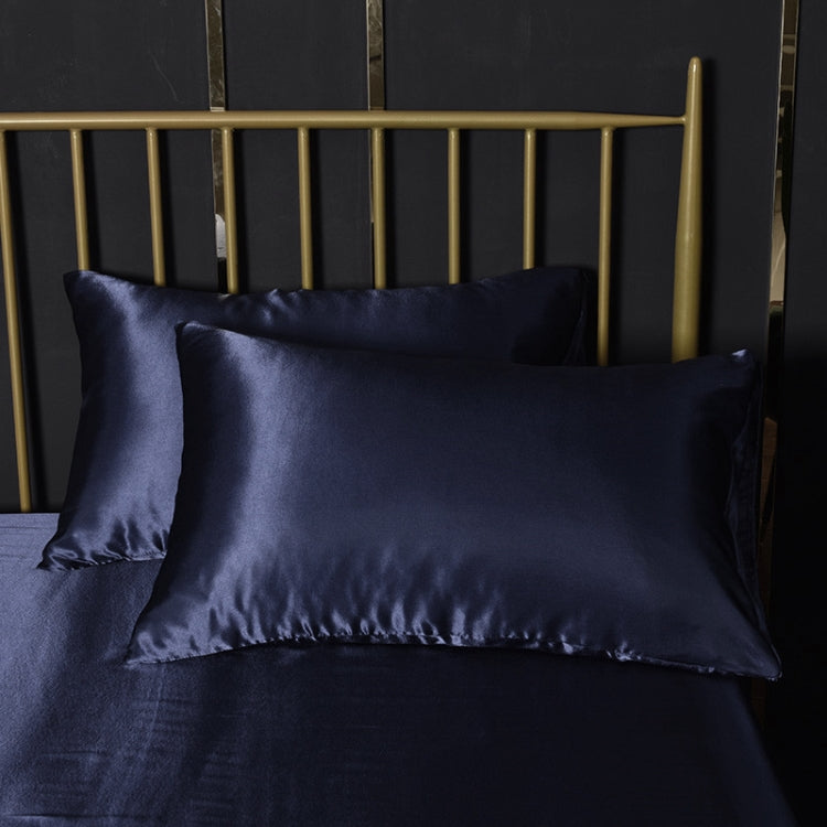 Navy silk-look pillowcase on bed, satin finish with subtle seam detail