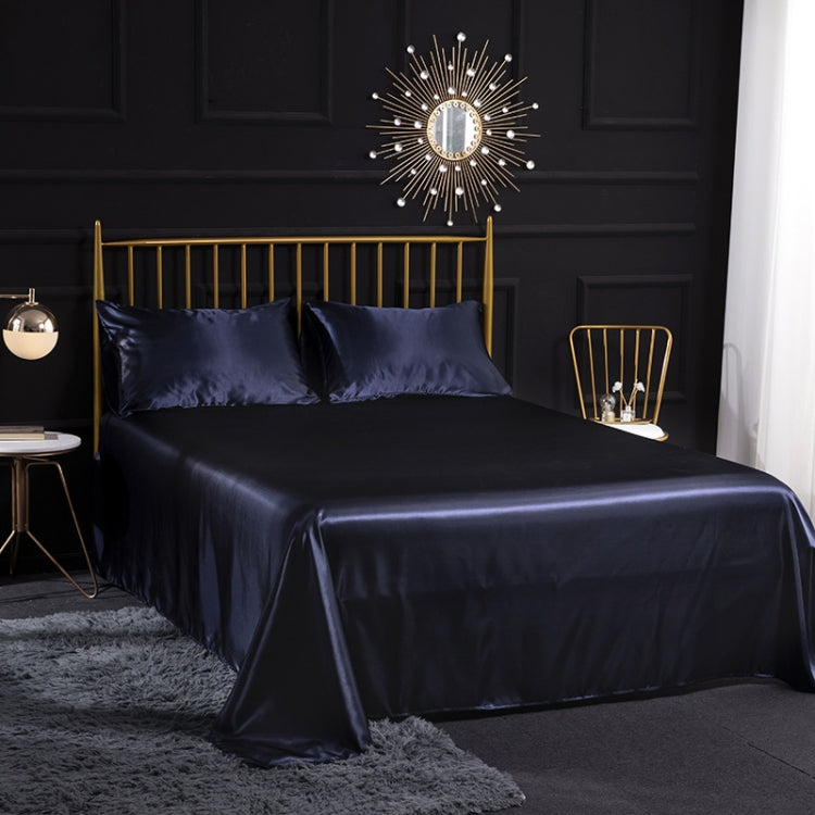 Royal blue silk-look sheet set with two pillowcases and draped flat sheet on bed
