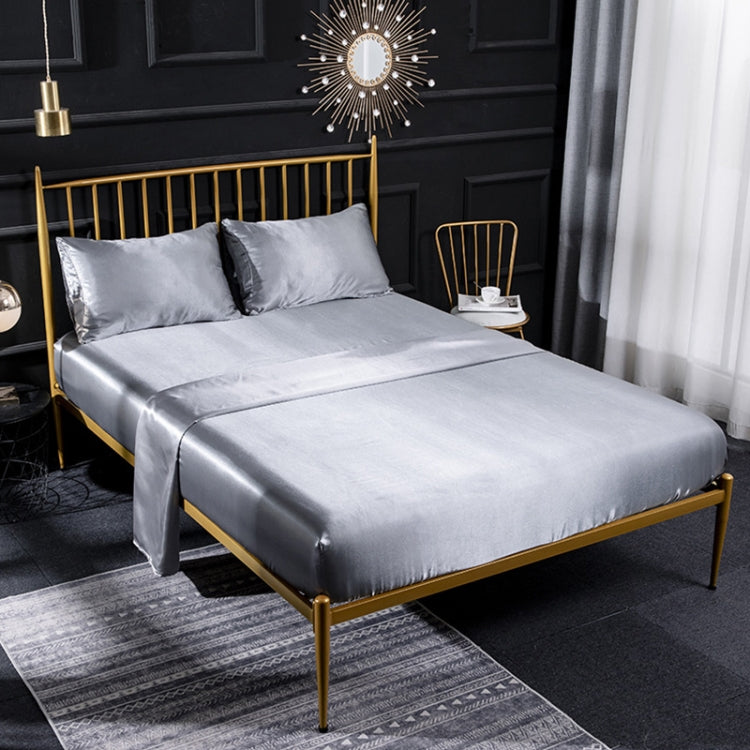 Silver gray satin-look four-piece bedding set with pillowcases and fitted sheet on bed