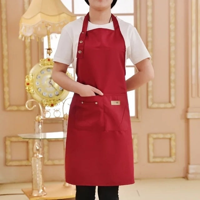 Red kitchen apron with adjustable neck strap and two front pockets.