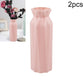 Pink plastic round vase with faceted sides and flared top opening, tall cylinder shape
